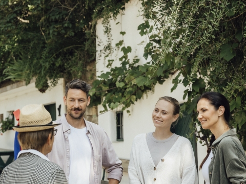 Gruppeninteraktion im Freien mit vier Personen, die miteinander sprechen.